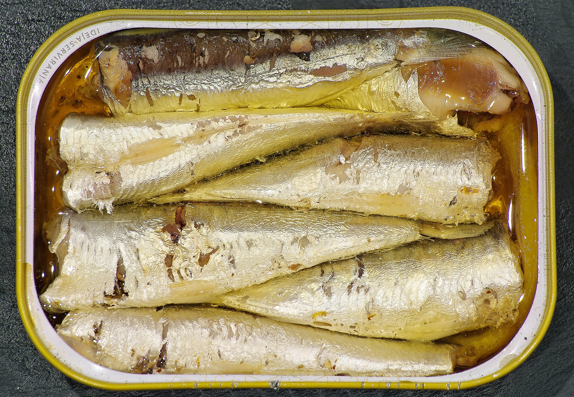 Open tins of sardines in olive oil with lemon, olives and bread