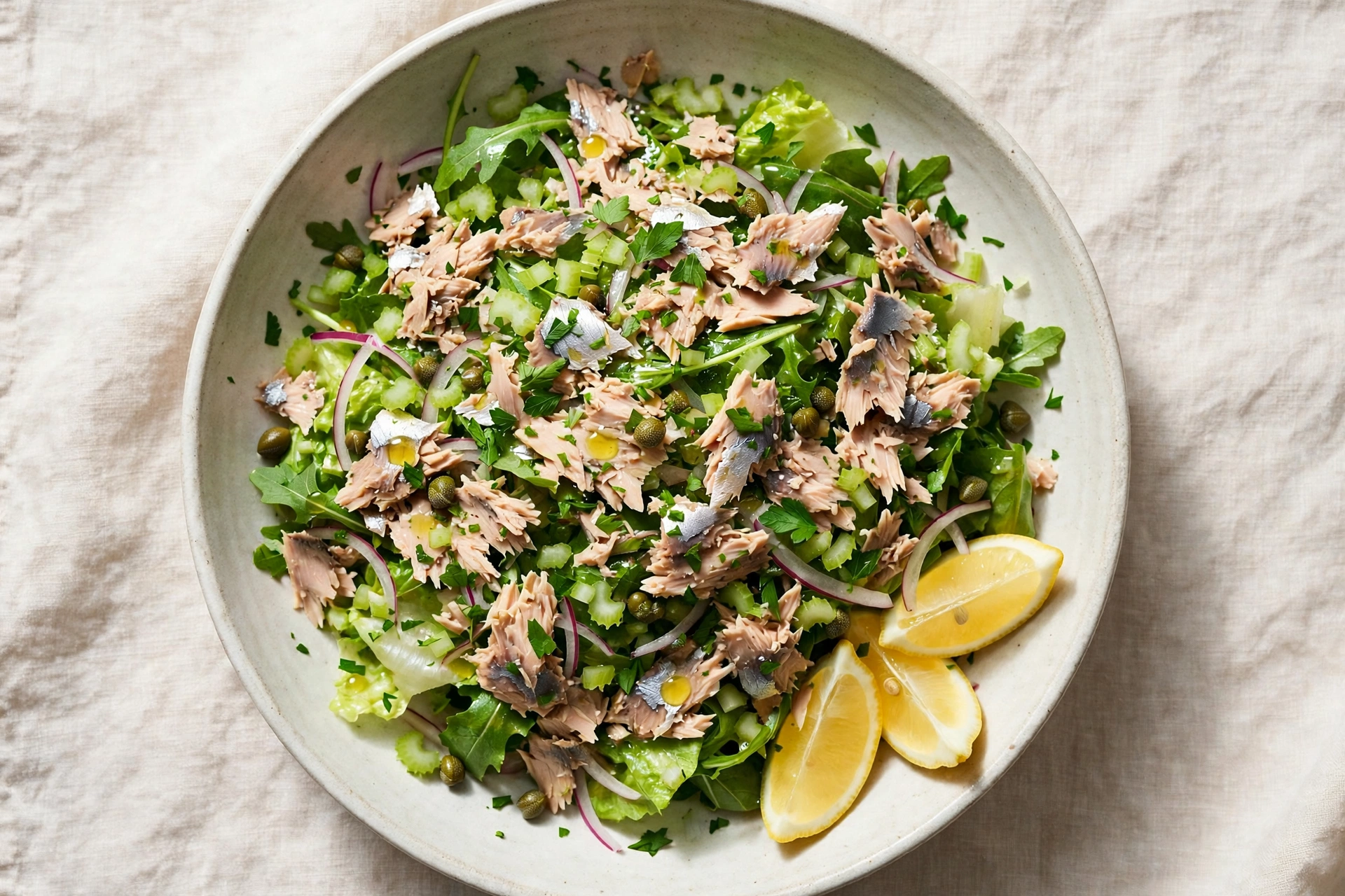 A bowl of sardine salad with celery, capers, herbs and lemon